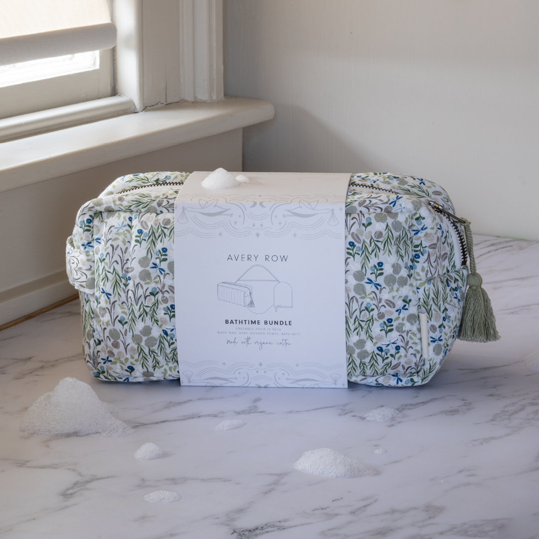 Floral-patterned toiletry bag with tassel on a marble surface, next to a product card labeled 'Avery Row'.