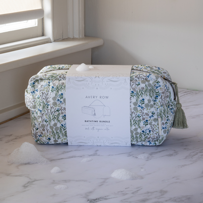 Floral-patterned toiletry bag with tassel on a marble surface, next to a product card labeled 'Avery Row'.