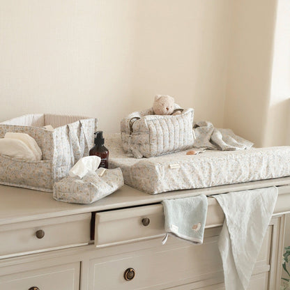 Baby changing table with baby items on a neutral background