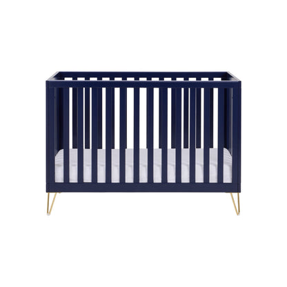 Navy crib with white mattress on a white background