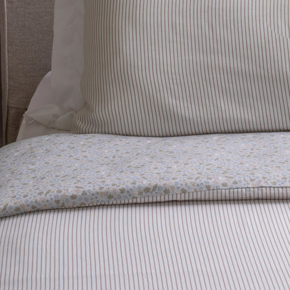 Close-up of a bed with striped bedding and a pillow
