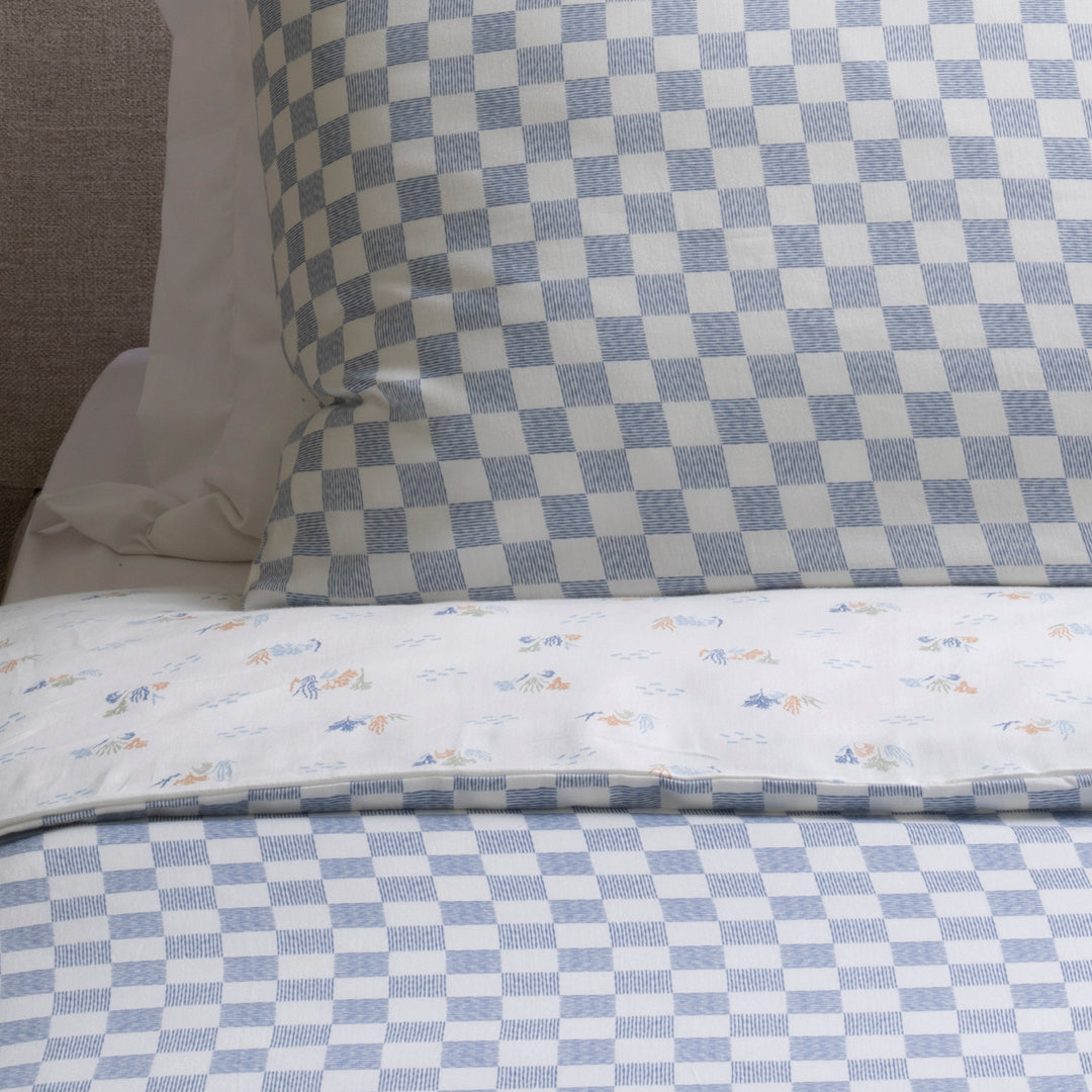Checkered bedspread with floral patterns on a bed