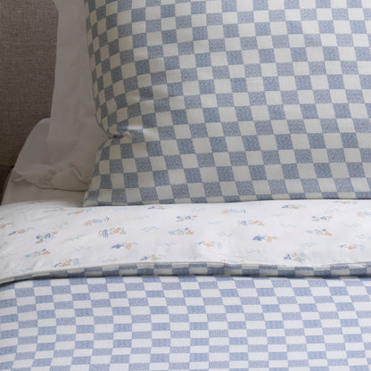 Checkered bedspread with floral patterns on a bed