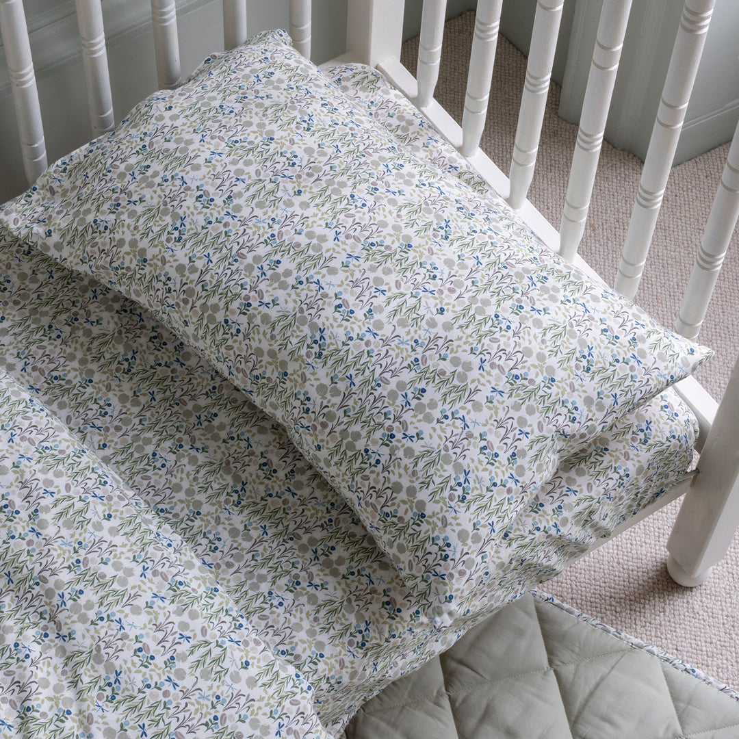 Floral-patterned quilt and pillow on a white crib
