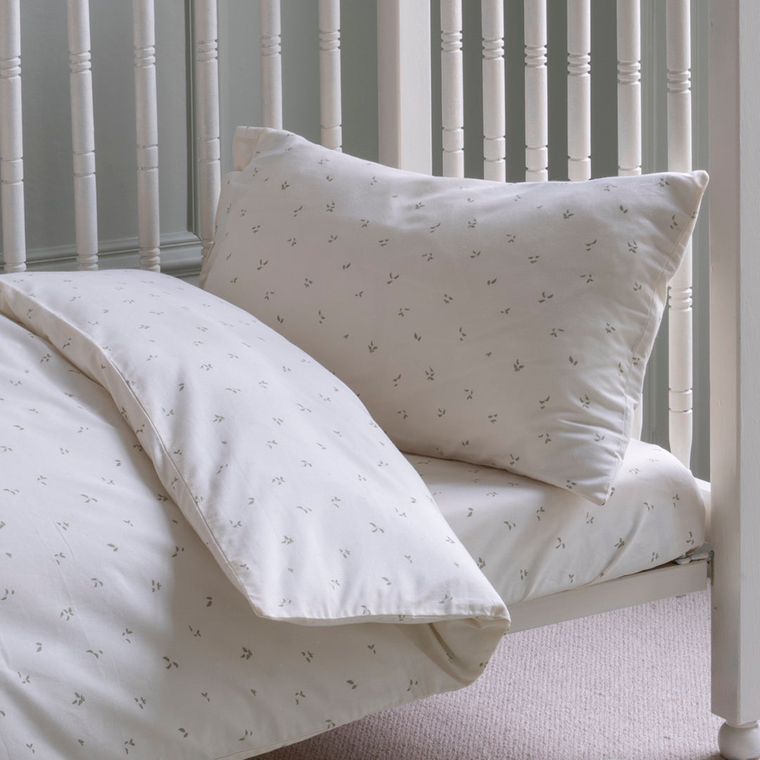 White bedding set with subtle pattern on a bed with white headboard