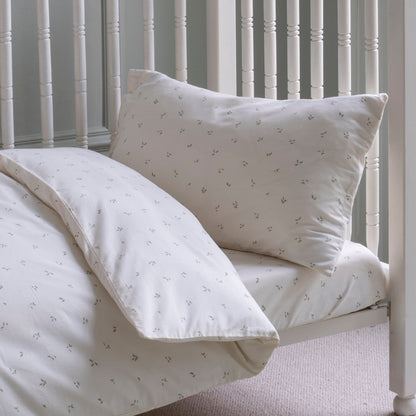 White bedding set with subtle pattern on a bed with white headboard