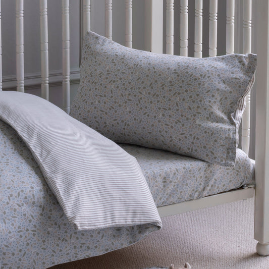 Floral patterned pillow and duvet on a bed with white headboard