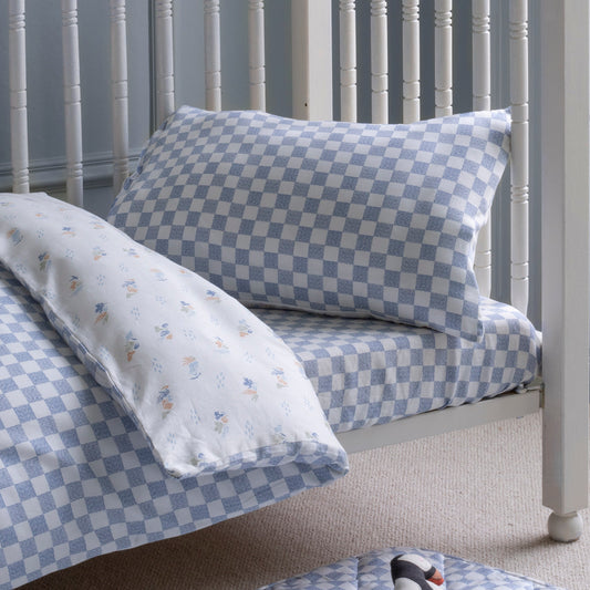 Blue and white checkered bedding set on a bed with a white headboard.