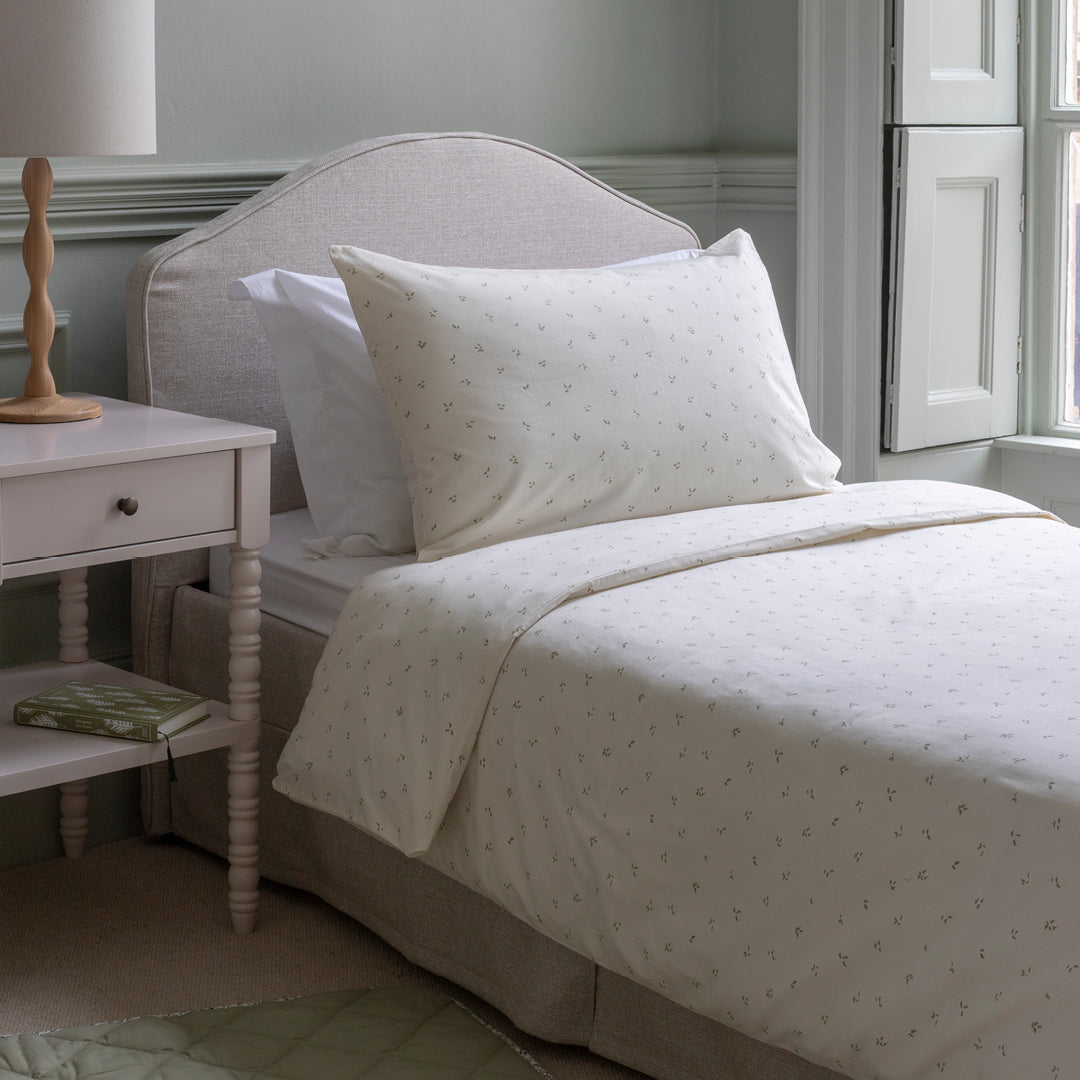 Neatly made bed with white bedding in a bedroom setting