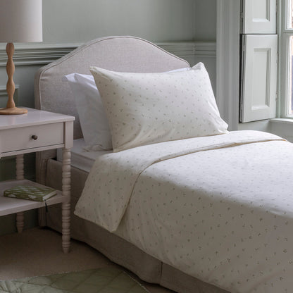 Neatly made bed with white bedding in a bedroom setting