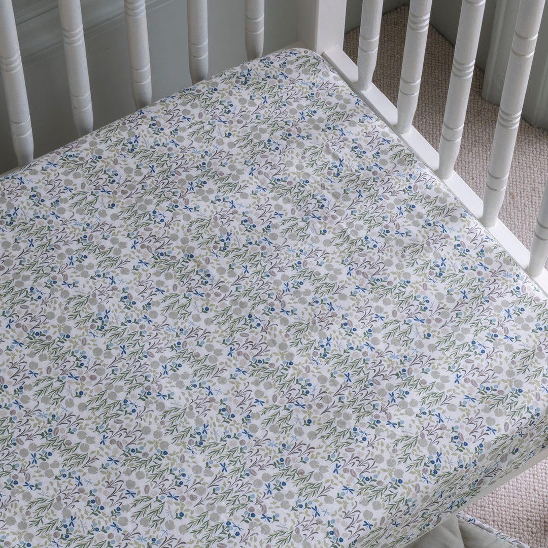 Floral patterned crib sheet on a white crib