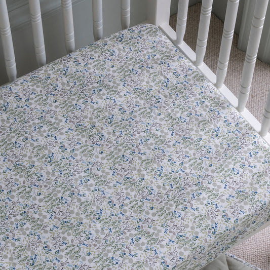 Floral patterned crib sheet on a white crib