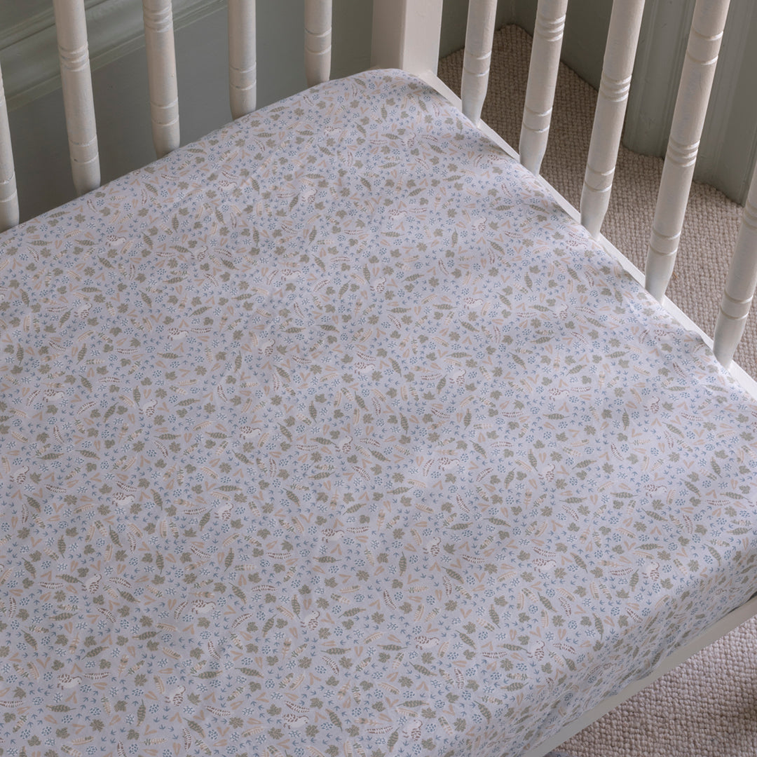Floral patterned crib sheet on a white crib