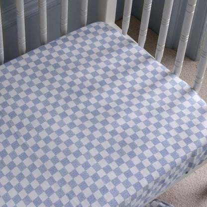 Crib with a blue and white checkered fitted sheet
