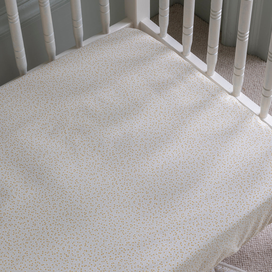 Crib mattress with a floral pattern on a white crib