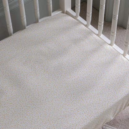 Crib mattress with a floral pattern on a white crib