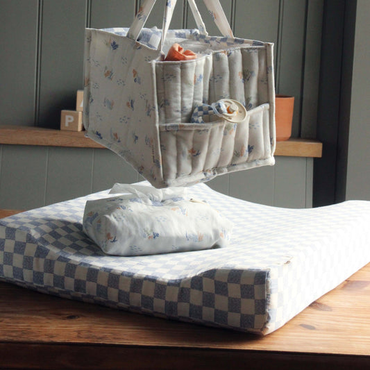 Baby changing bag with items on a changing mat in a nursery setting