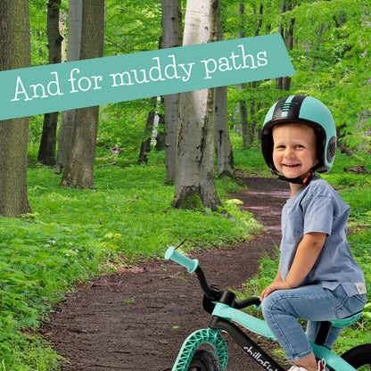 Child on a bike in a forest with a helmet, text 'And for muddy paths' at the top.