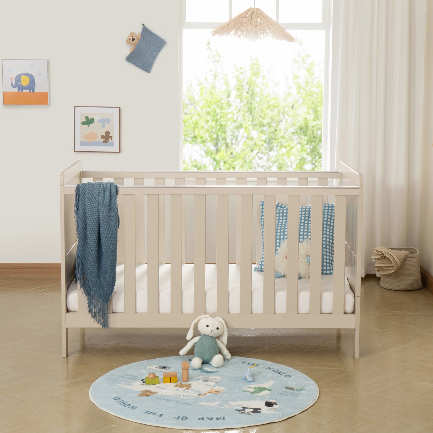 Nursery room with a cot, teddy bear, and round rug featuring animals.