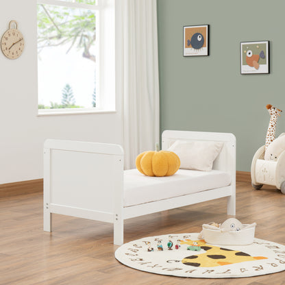 White children's bed in a room with toys and decor