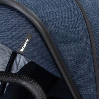 Close-up of a blue textured fabric with black piping and a visible brand label.