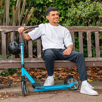 Man sitting on a bench with a blue scooter, wearing a helmet.