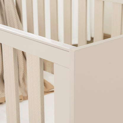 Beige cot with a soft beige blanket inside, on a light background