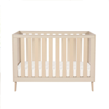 Beige cot with white mattress on a white background