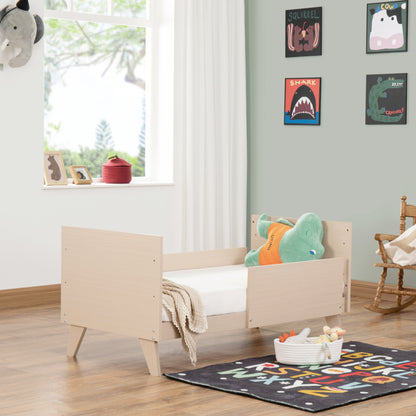 Children's bedroom with a wooden toddler bed, colourful rug, and wall decorations.