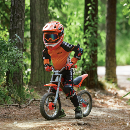 Child riding a balance bike in a forest setting