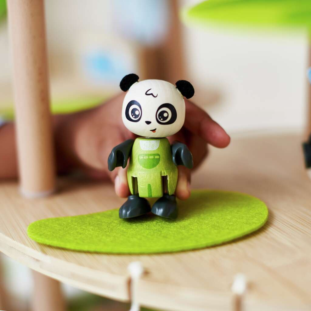 Panda toy figure on a green platform with a blurred background