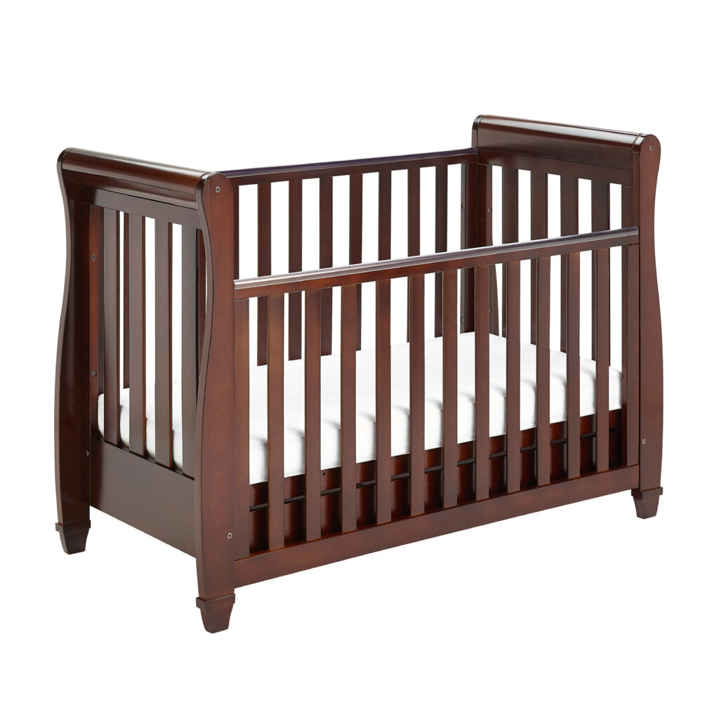 Wooden crib with white mattress on a white background
