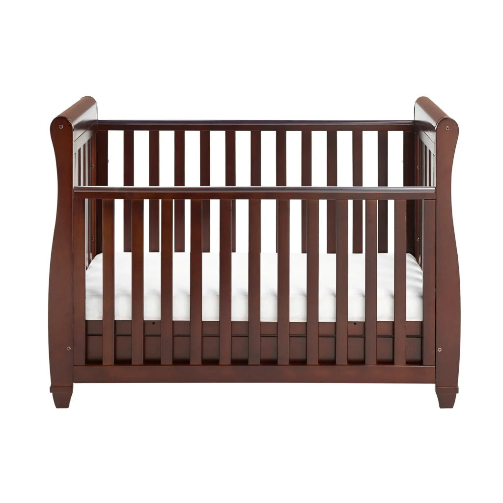 Wooden crib with white mattress on a white background