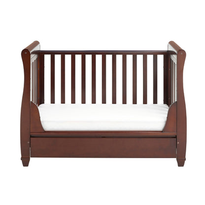 Wooden crib with white mattress on a white background