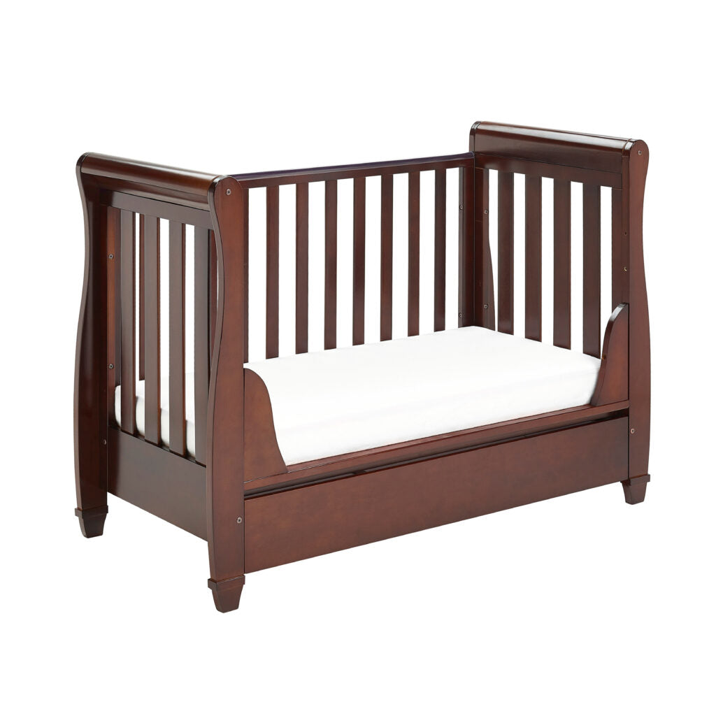 Wooden crib with white mattress on a white background