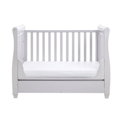 White crib with a white mattress on a white background