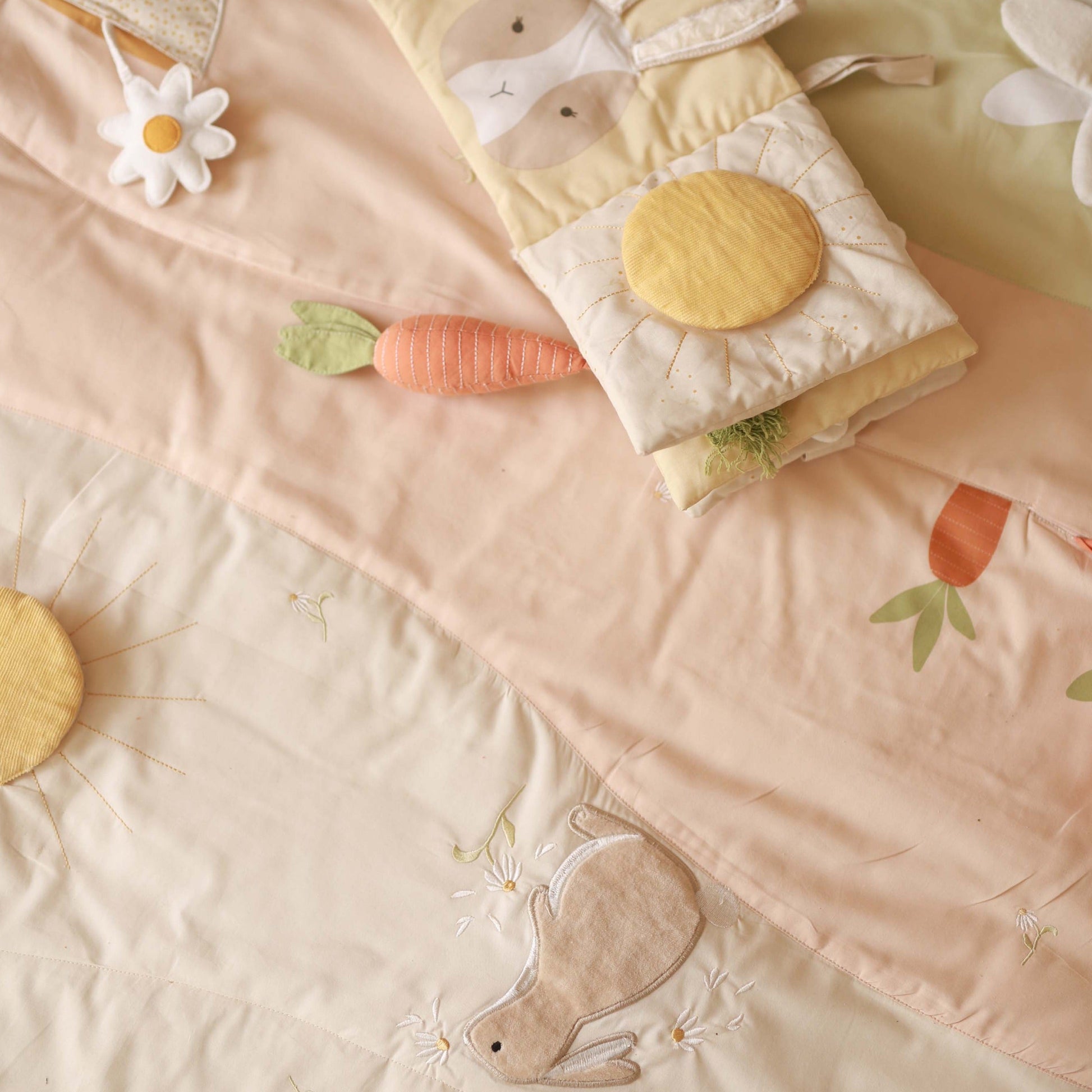 Children's quilt with rabbit and carrot design on a soft pink background