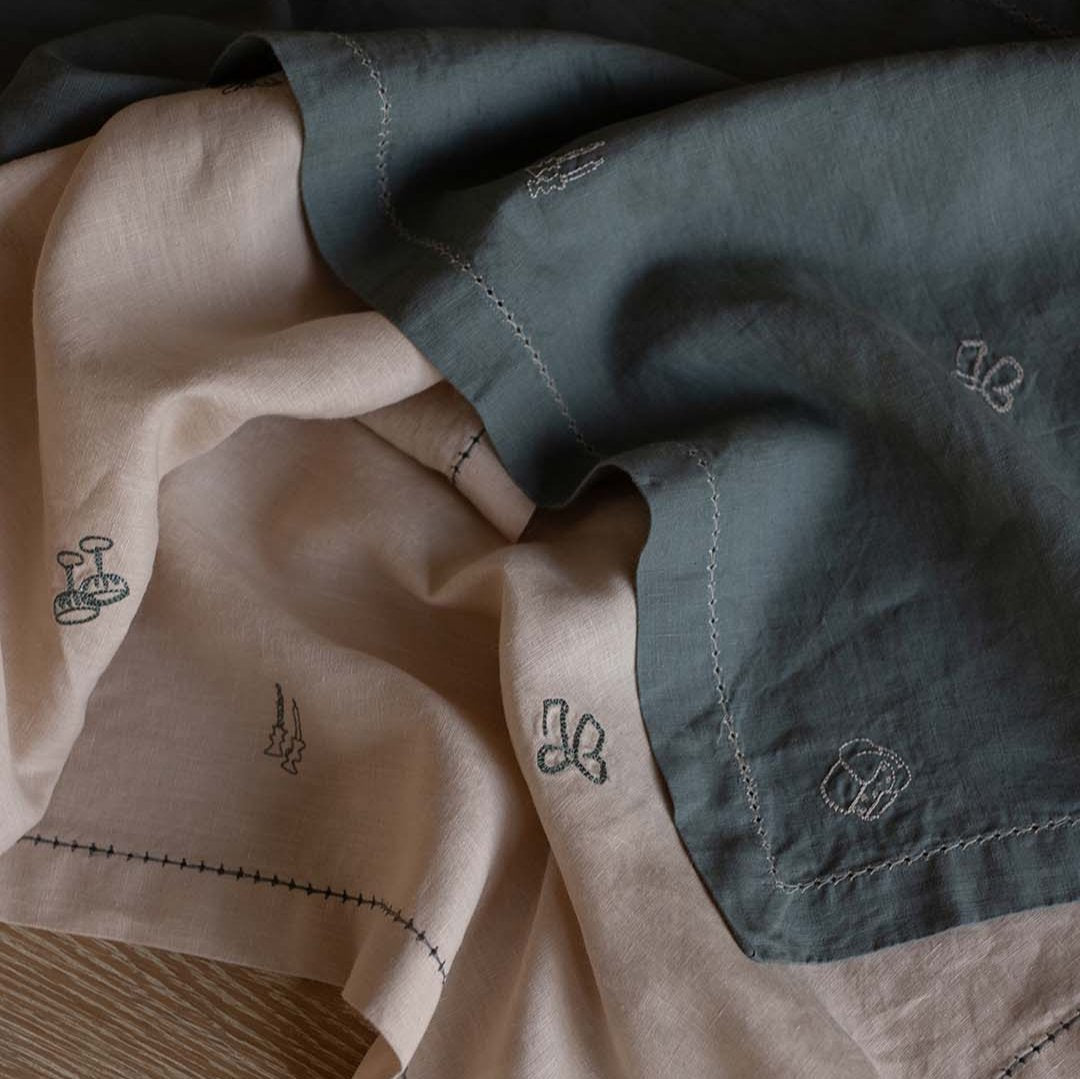 Close-up of fabric with embroidered designs on a wooden surface