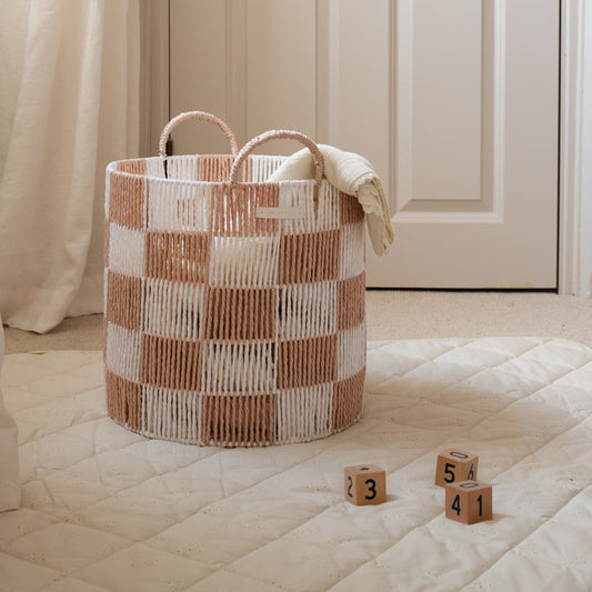 Woven basket with checkered pattern on a quilted surface