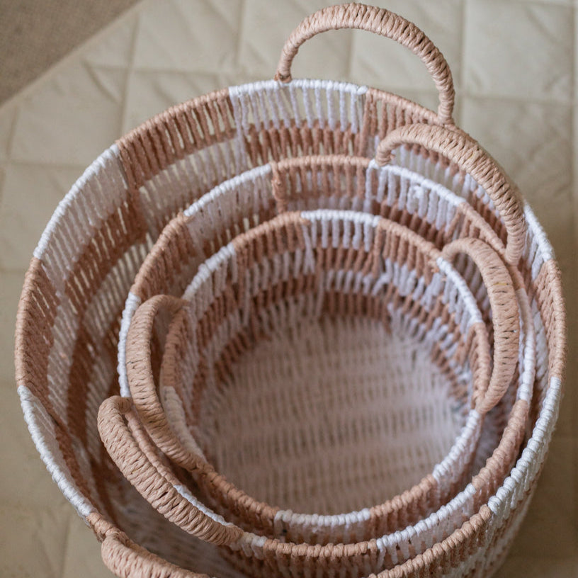 Set of nested woven baskets on a neutral background