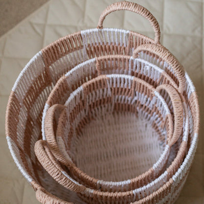 Set of nested woven baskets on a neutral background
