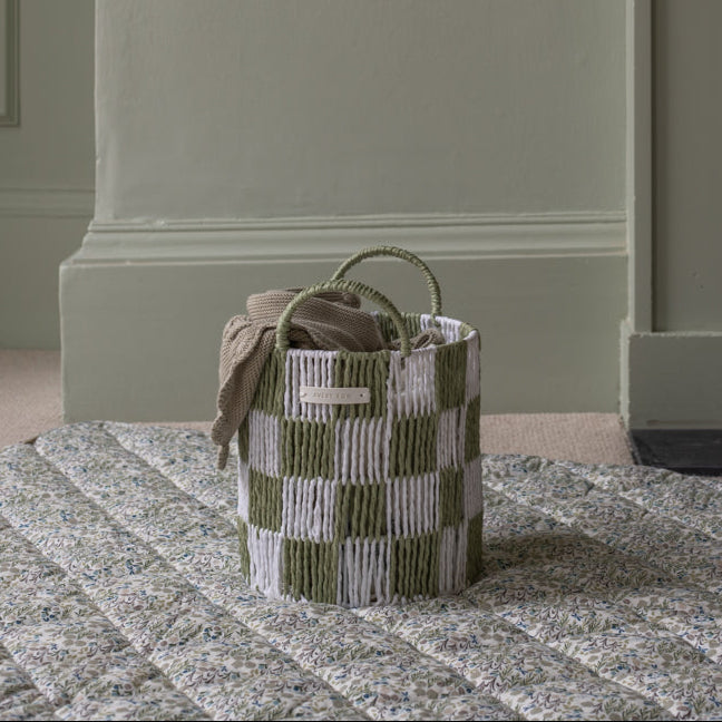 Woven basket with striped pattern on a textured surface