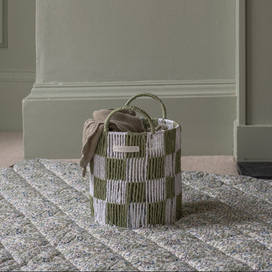 Woven basket with striped pattern on a textured surface
