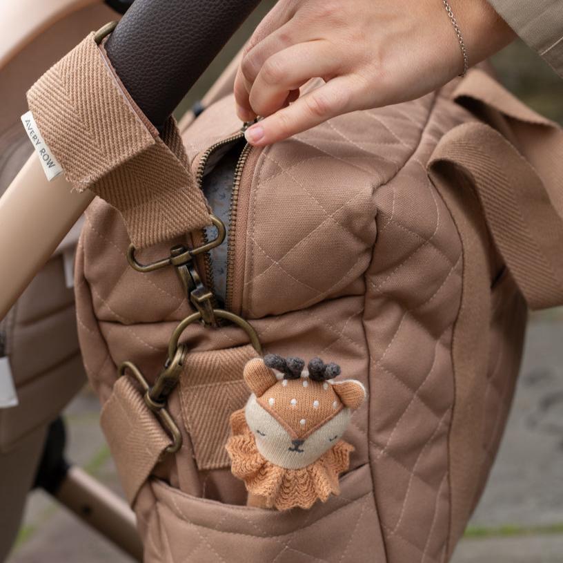 Stuffed animal keychain attached to a brown quilted bag