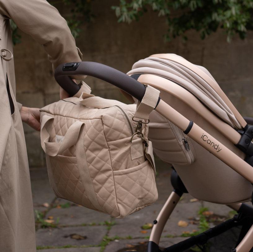 Beige quilted diaper bag attached to a stroller with 'iCandy' branding.