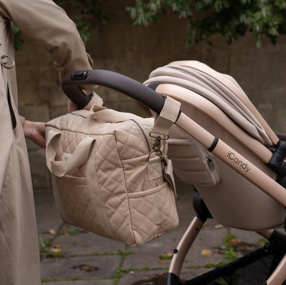 Beige quilted diaper bag attached to a stroller with 'iCandy' branding.