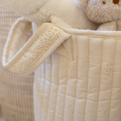 Close-up of a baby's quilted jacket with a teddy bear on a neutral background