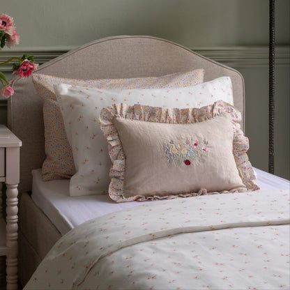 Bed with floral bedding and pillows in a bedroom setting