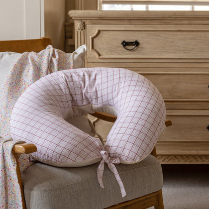 Checkered neck pillow on a chair in a bedroom setting