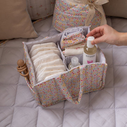 Fabric storage basket with baby items on a bed